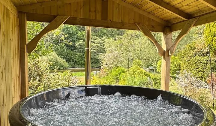 A bubbling hot tub beneath a timber gazebo