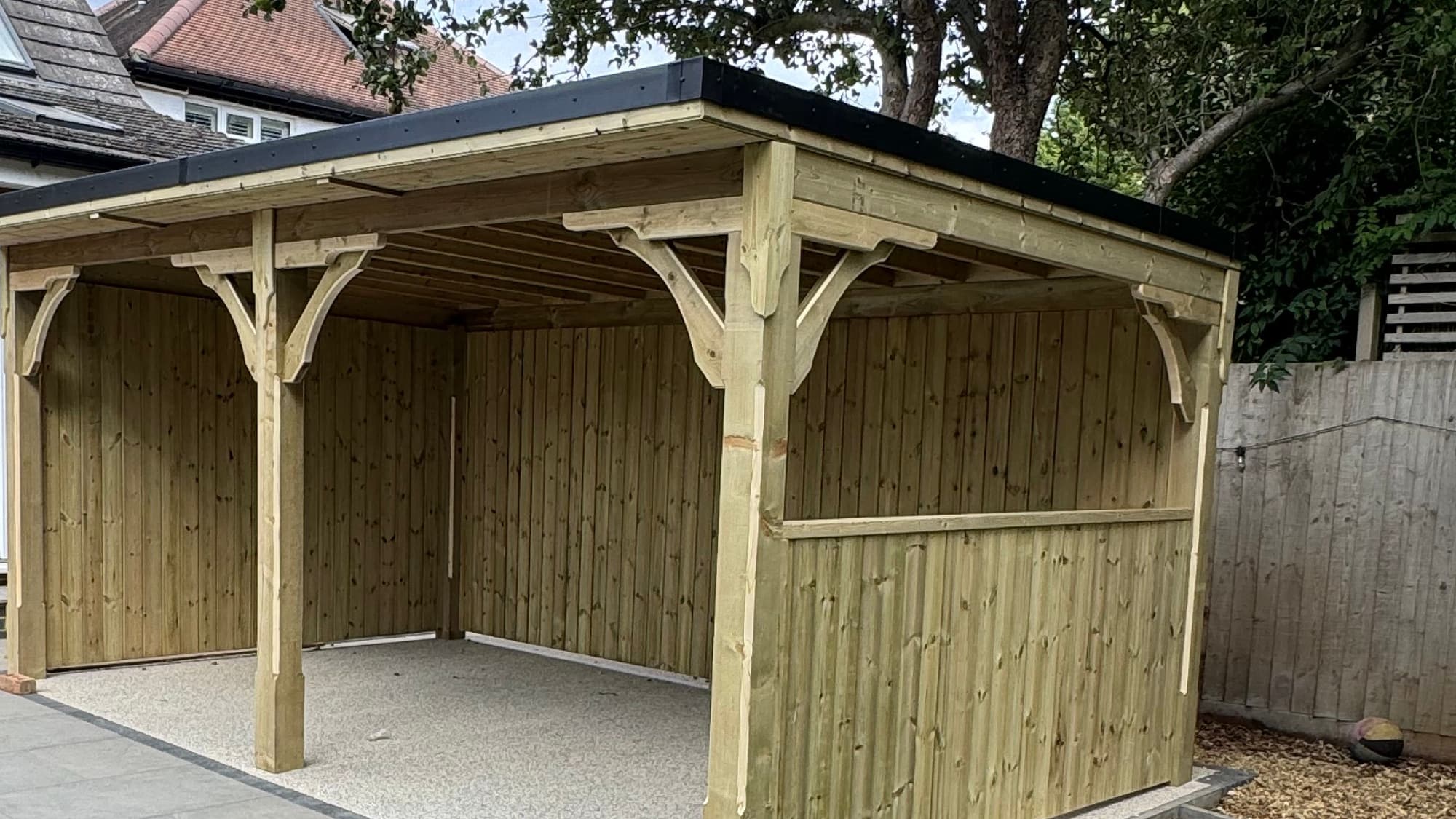 A pent roof timber gazebo with part-clad sides on a porcelain patio