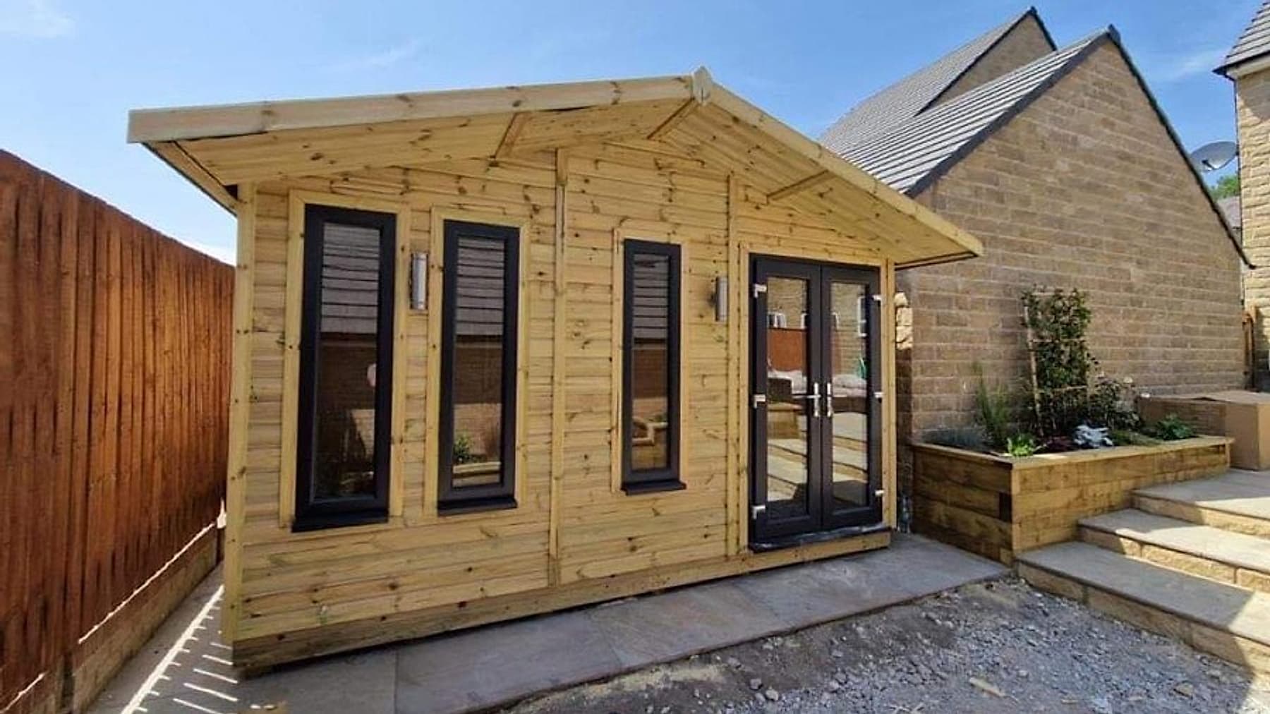 A chalet-style timber summer house in a garden