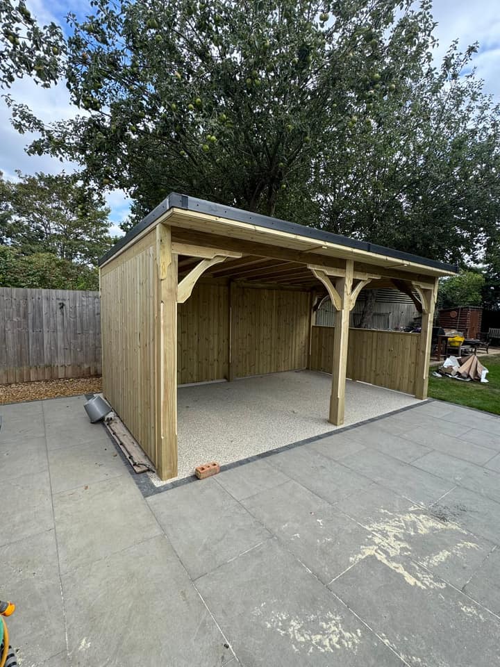 A pent roof timber gazebo with part-clad sides on a porcelain patio