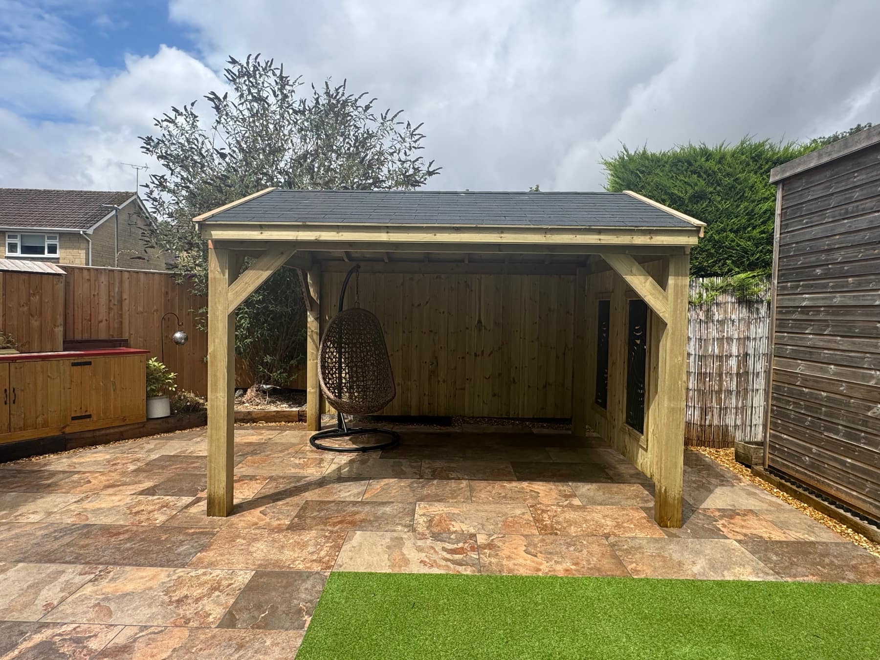 The Kensington gazebo, a handcrafted timber gazebo with a gabled roof and privacy panels, on a tiled patio